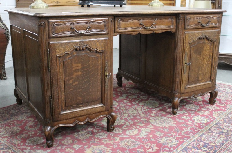 French provincial oak twin pedestal partners desk, fitted with drawers and cupboards.