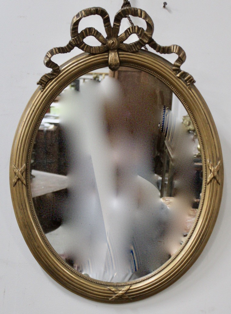 Decorative French gilt & ribbon decorated oval wall mirror.