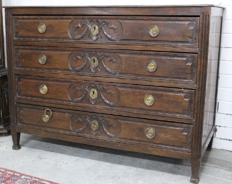 Early 19th century French oak & floral carved four drawer commode with bronze handles.