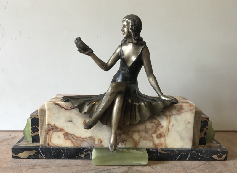 Art deco maiden figured statue seated on a marble and onyx base.