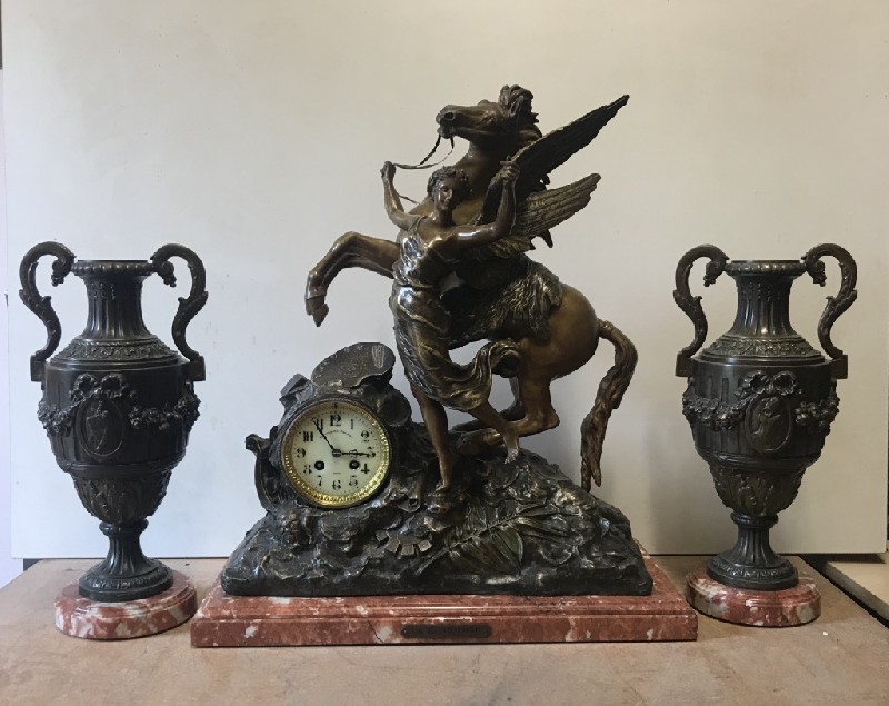 Three piece French 19th century speller angle figured clock garniture on rouge marble base.