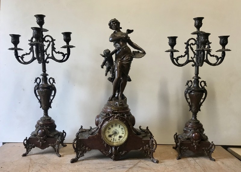 Three piece French 19th century spelter maiden figured clock set on rouge marble base.