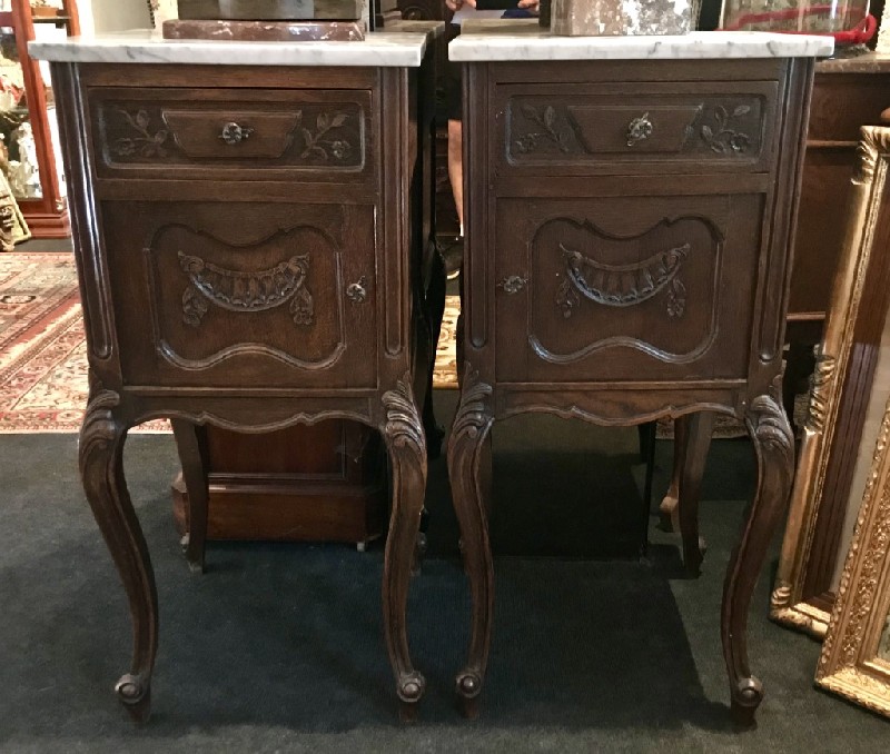 Pair of French Louis XVth carved oak bedside cabinets with white marble tops.