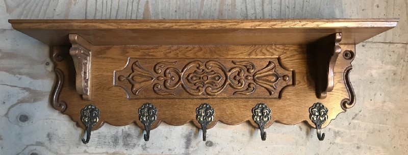 French carved oak coat rack with brass hooks.