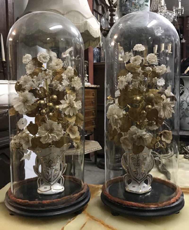 Pair of antique French glass domes on stand with flower arrangement.