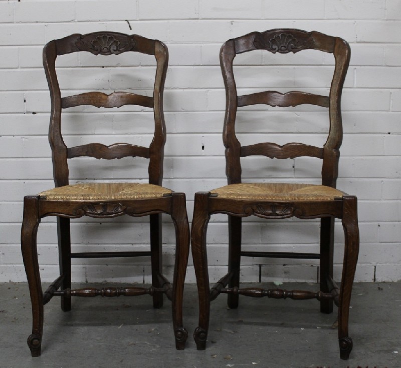 Set of six French country oak ladder back dining chairs with rush seats.