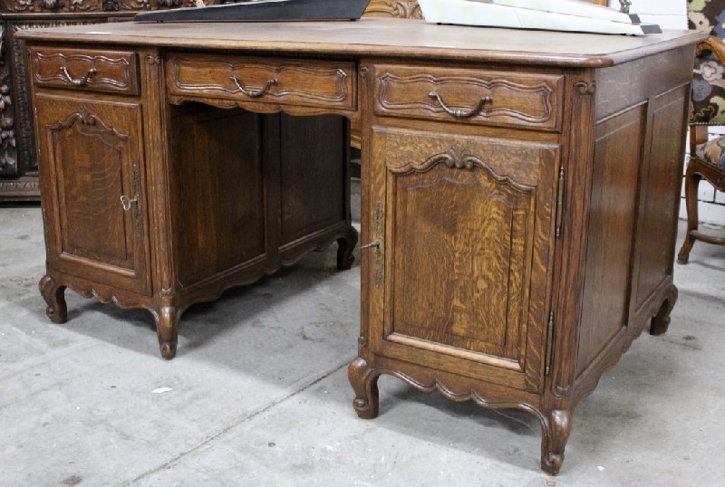 French provincial oak twin pedestal writing bureau with floral carved doors having drawers inside. 
