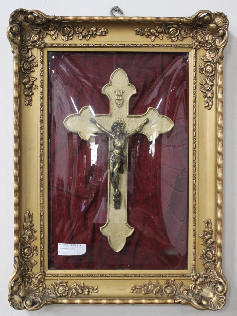 Gilt framed religious crucifix under convex glass.