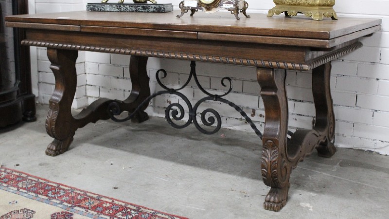 French early 20th century oak pedestal draw-leaf dining table with decorative wrought iron base.