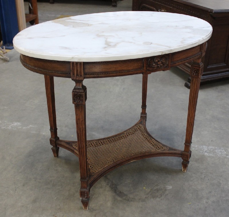 French Louis XVIth walnut and white marble top oval sofa table, having cane panlled base. Price $1200.