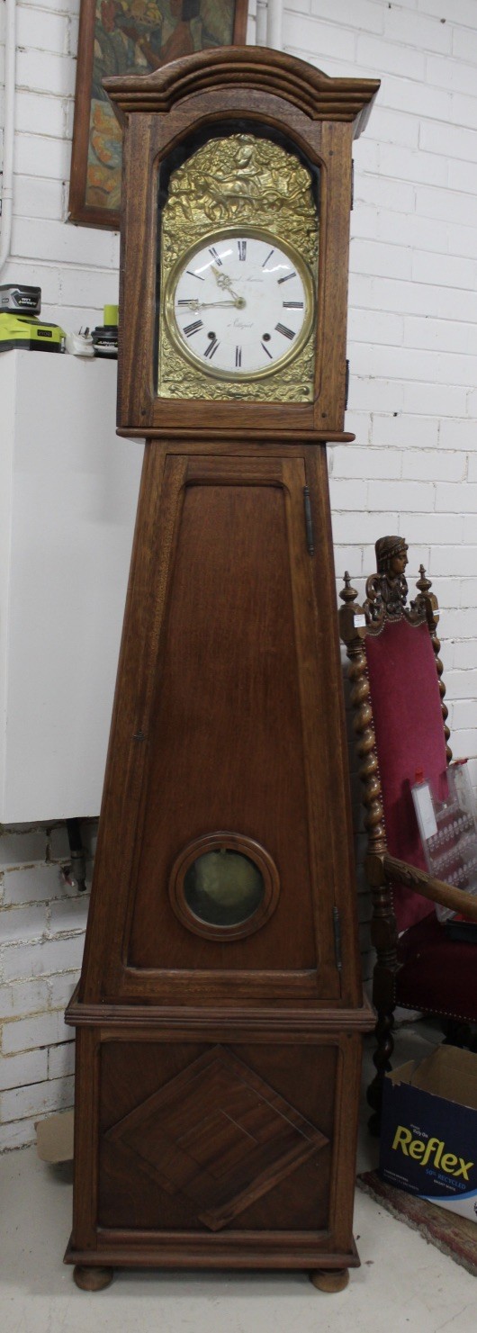 French provincial oak cased grand father clock, with vineyard brass dial and pendulum. Price $1100